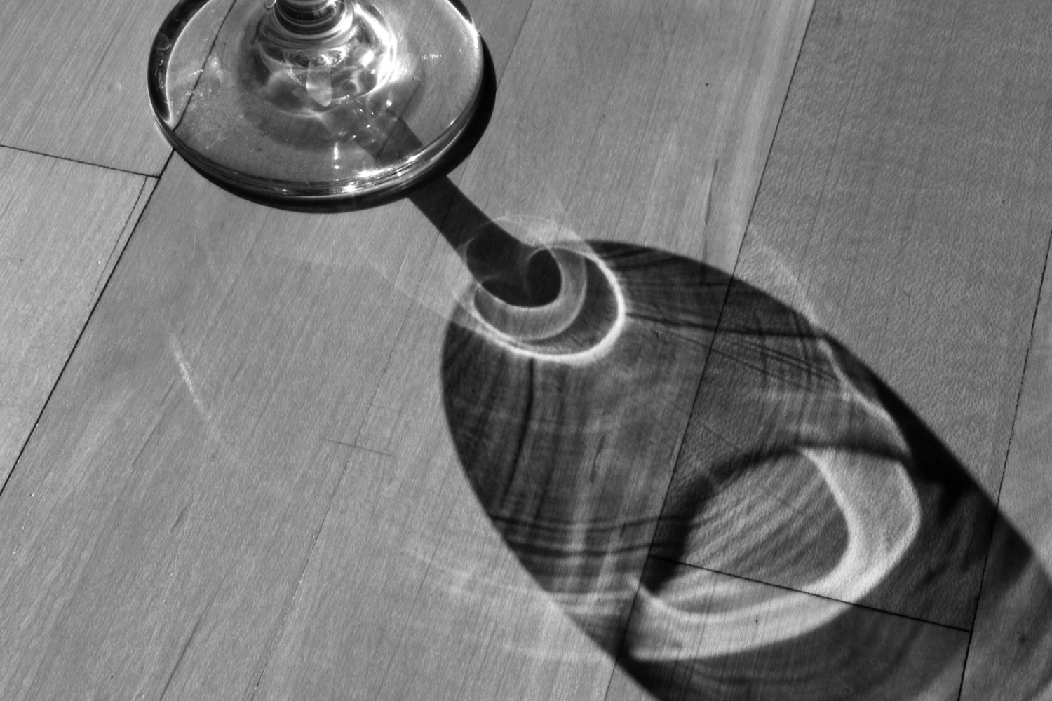 Photo of a wine glass reflecting sunlight by Chloe Atchue-Mamlet